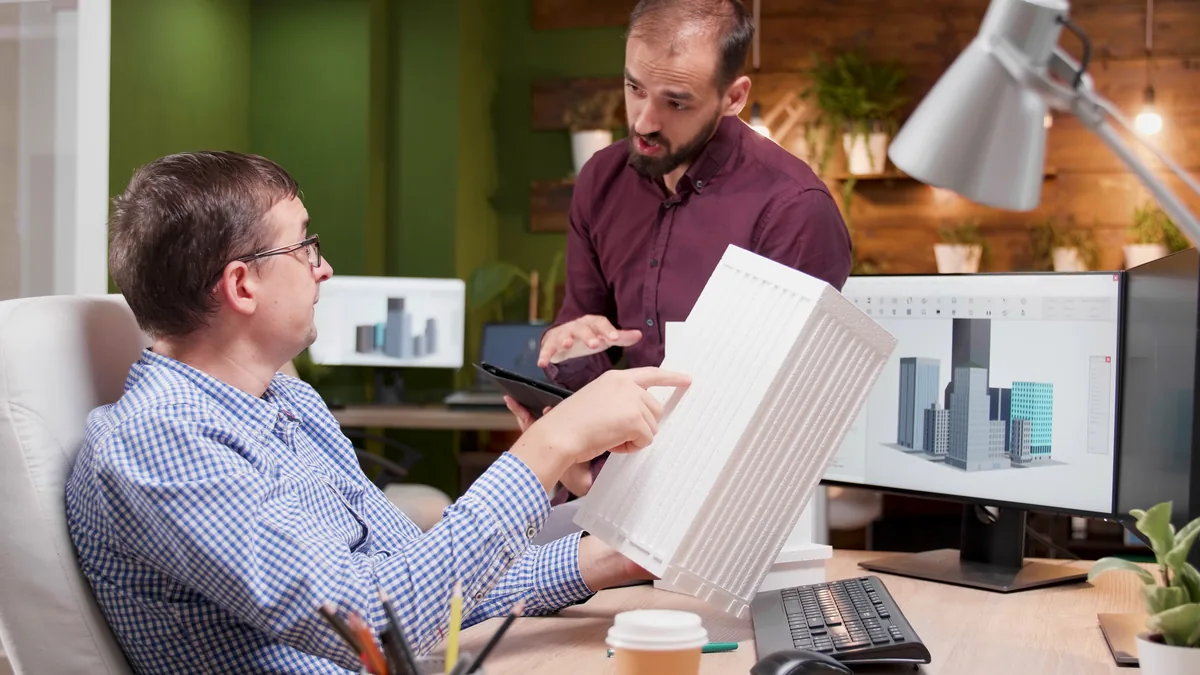 Mesa de trabalho de indústria com notebook exibindo campanha de marketing digital em Joinville e peça usinada ao lado