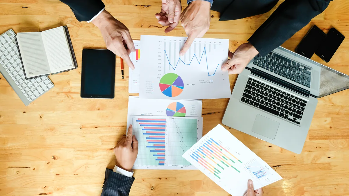 Mesa de reunião com plano em quatro fases e planilha de custos para calcular quanto custa montar uma estrutura de marketing digital