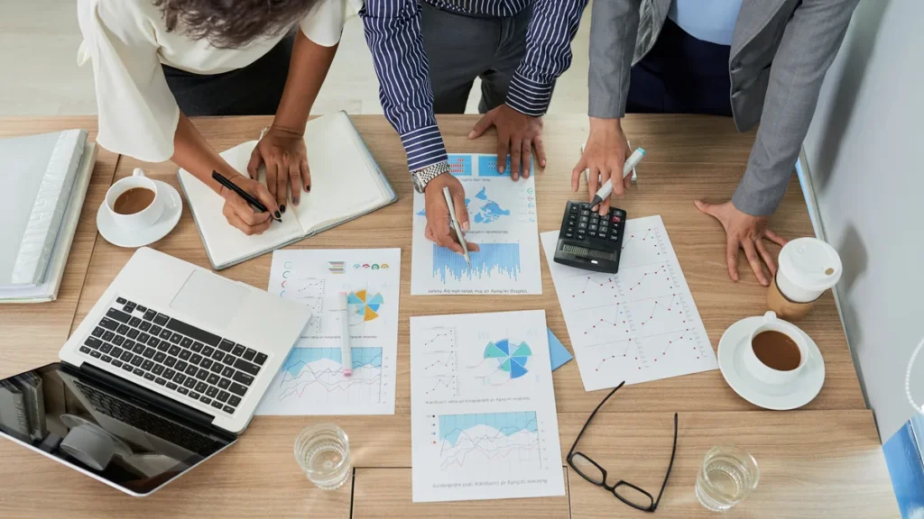 Mesa de trabalho com planilha e plano de mídia usados para calcular quanto investir em tráfego pago