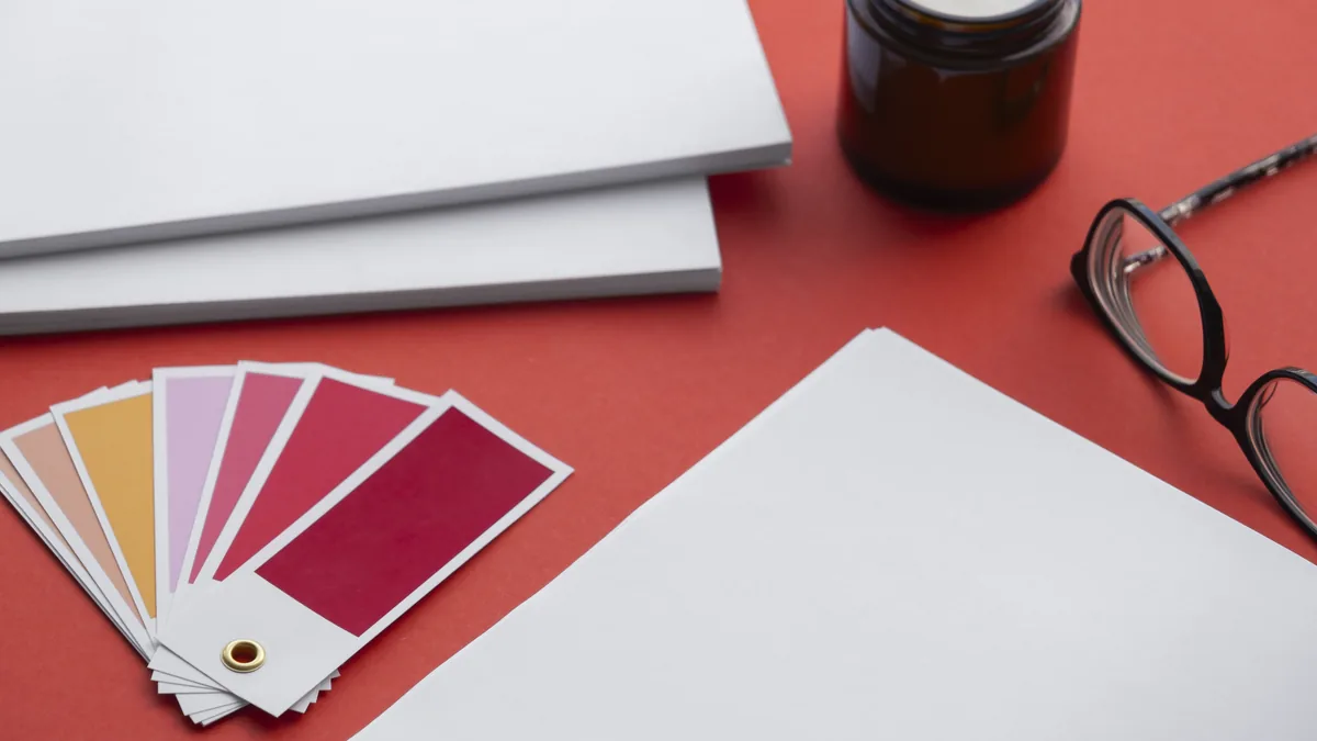 Mesa de reunião com manuais de marca e inventário de peças em branco durante um projeto de rebranding
