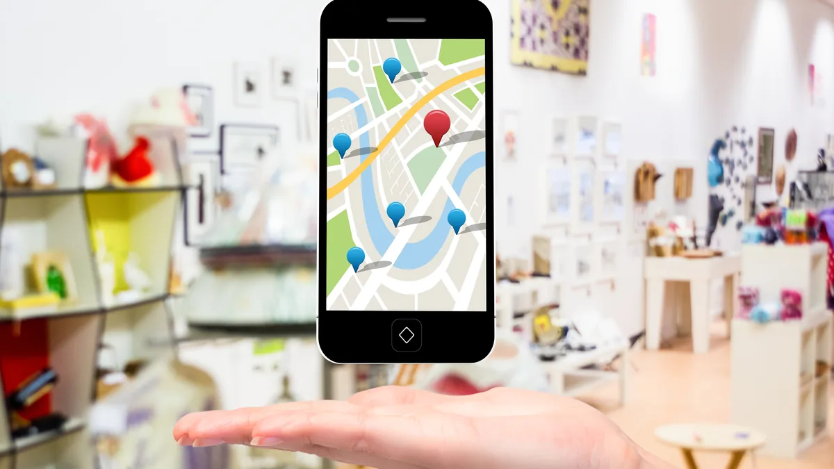 Celular sobre mesa de escritório exibindo mapa com três resultados, ilustrando SEO local